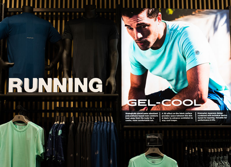 inside of a store, the word running sits next to a photo of a young man hunched over with the words gel-cool written over him