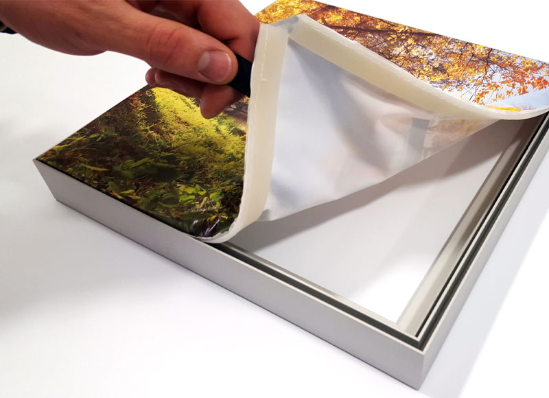 a hand pealing a high quality photo off of an seg frame